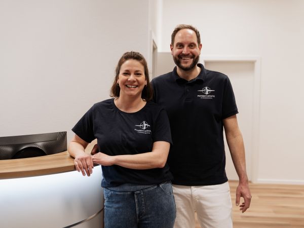Mona und Benjamin Zimmermann stehen im Empfangsbereich der Physiotherapie Praxis im Kornmakrt
