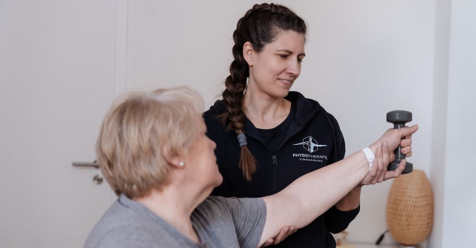 Eine Physiotherapeuting unterstützung eine Patientin beim Muskelaufbautraining für die Schulter