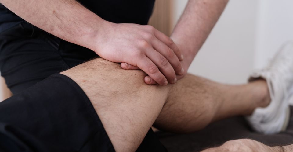 Titelbild des Headers - Eine Person wird am Knie behandelt